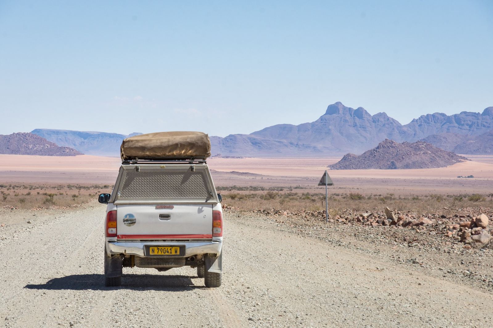 A 4x4 on a Namibian gravel road with mountains ahead
