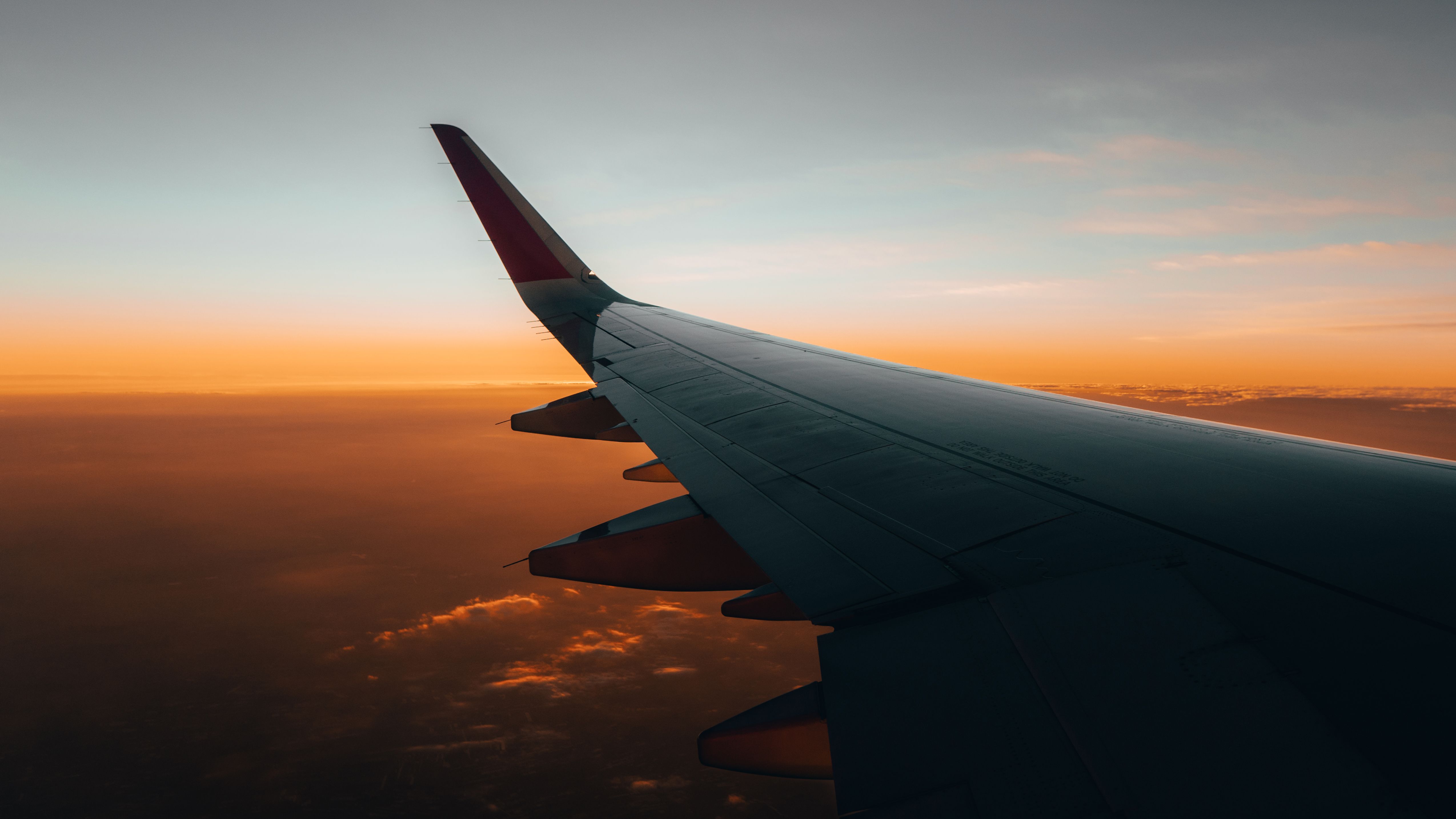 An airplane wing seen from the cabin at sunset